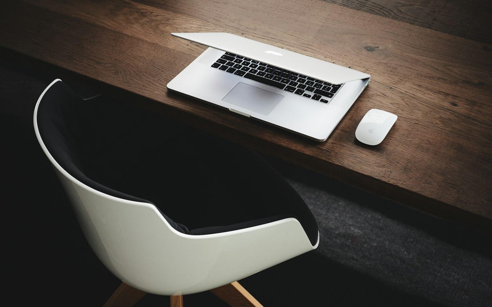 An overhead view of a tidy desk with a laptop and notebook.