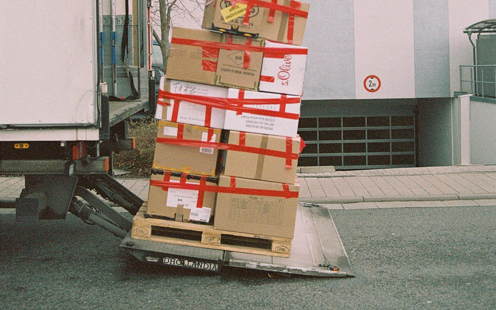 Stacked cardboard cartons on a pallet in a warehouse.